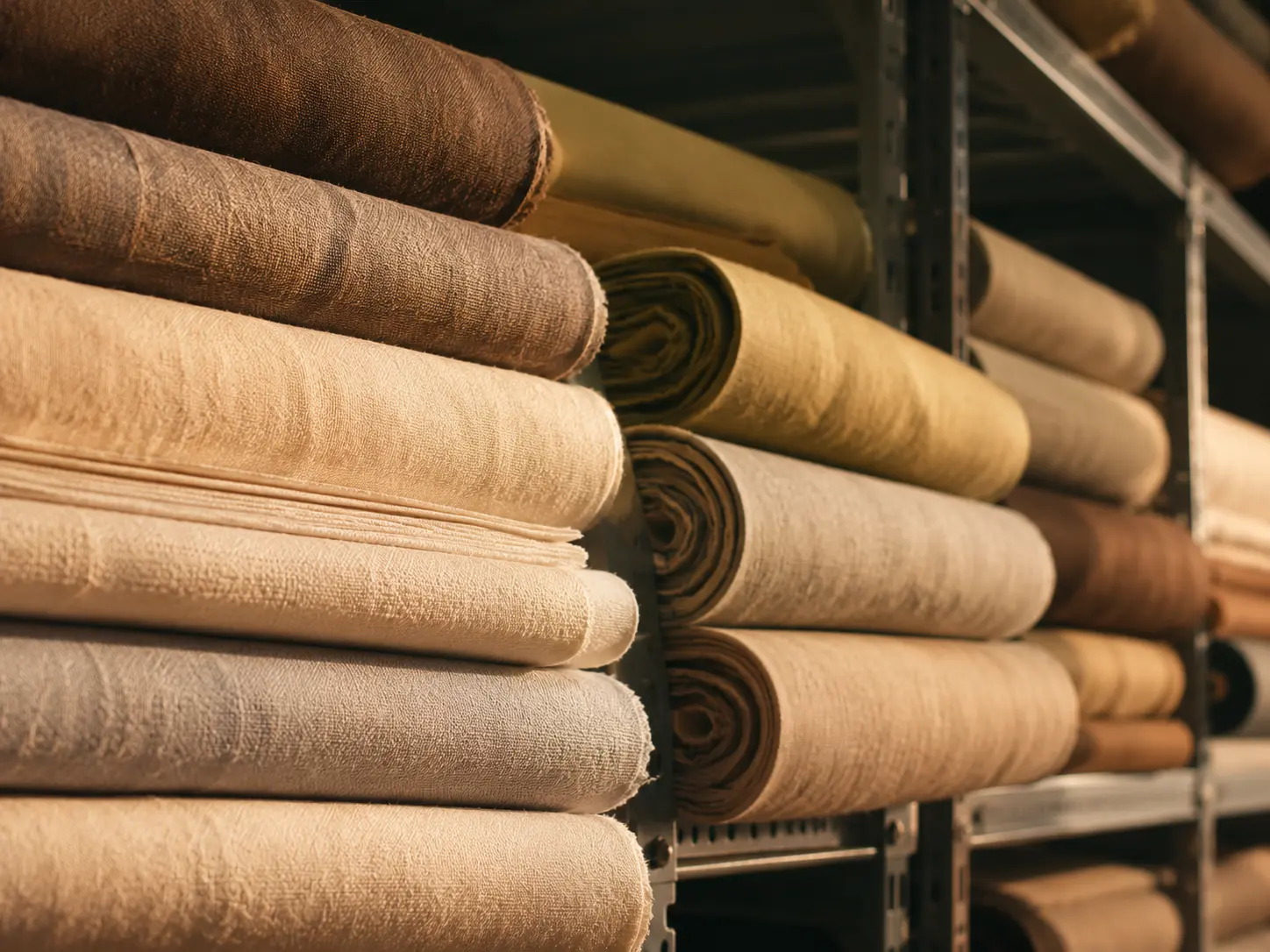 Rolls of fabric stacked in a textile facility.